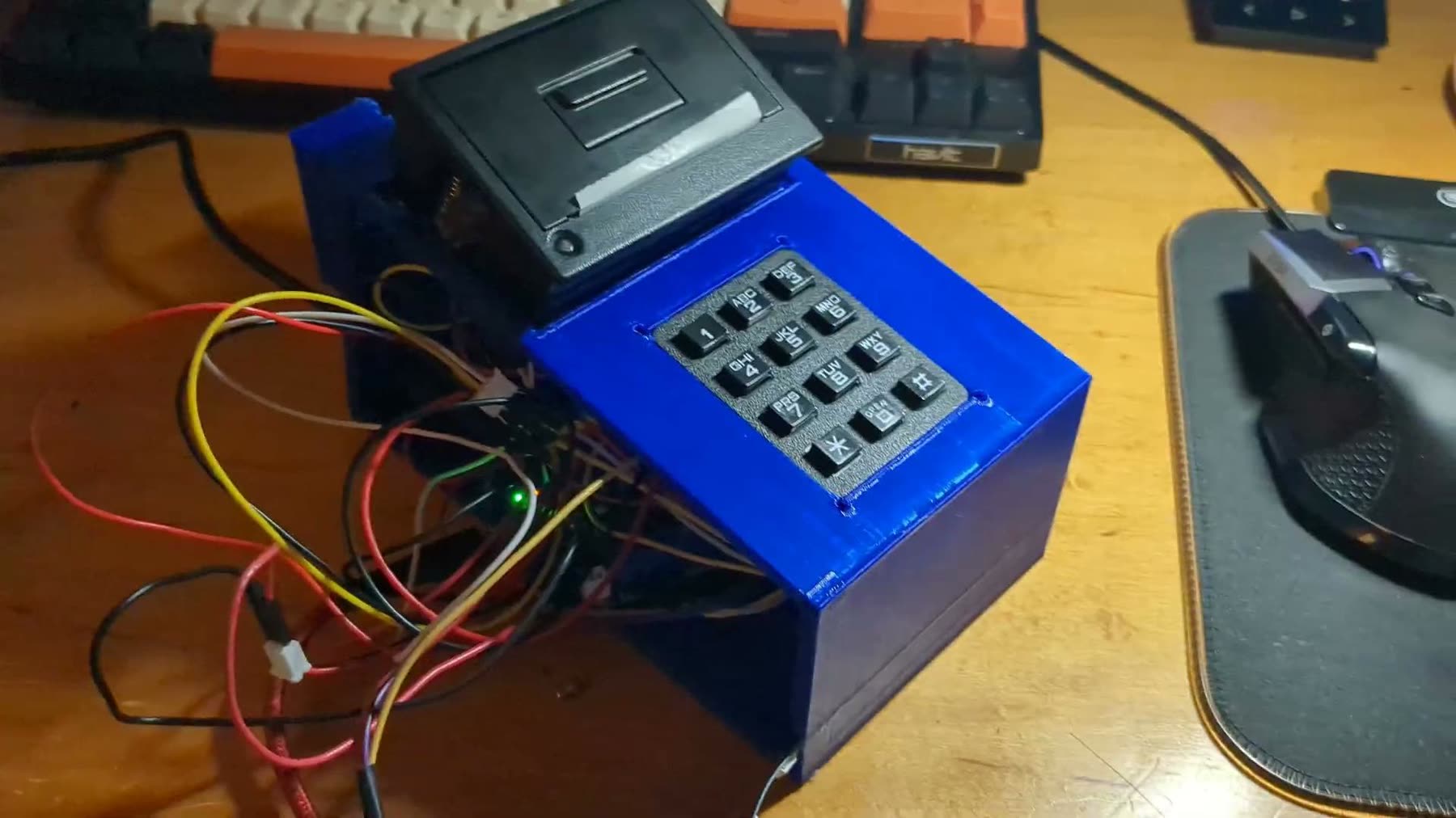 The A.T.P.S. kiosk, a blue 3D-printed box with a keypad and a receipt printer
